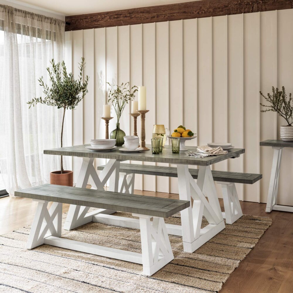 All wood white and grey extendable dining table with two benches in well lit dining room