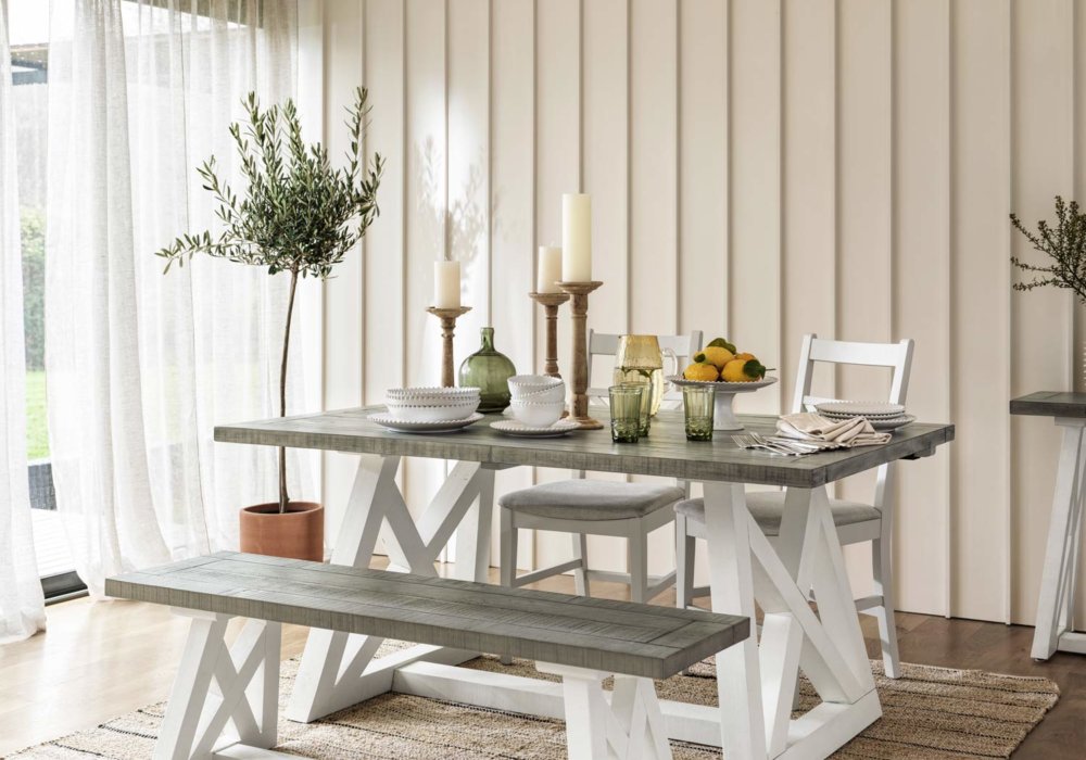 White & Grey extendable dining table set with white base sat in well lit dining room, with 2 dining chairs and bench
