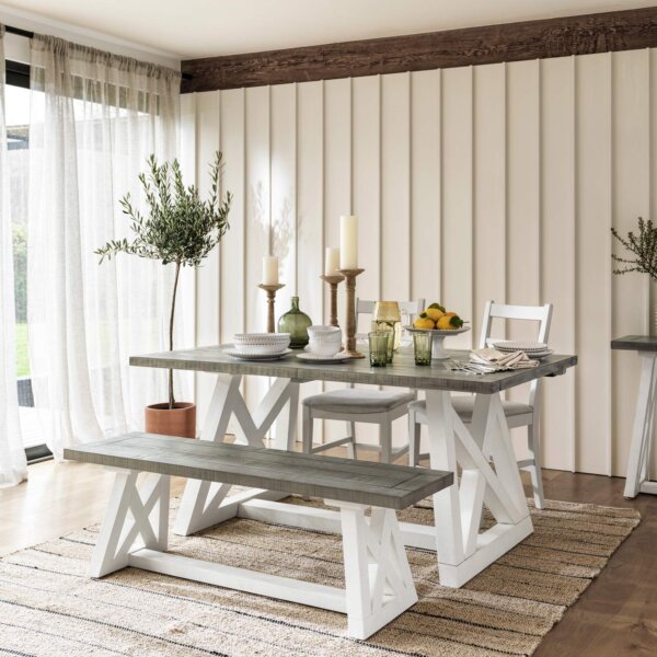 White & Grey extendable dining table set with white base sat in well lit dining room, with 2 dining chairs and bench