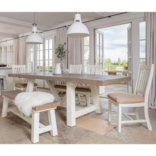 modern farmhouse dining table in front of open patio door with both ended of table extended. 4 x matching chairs on far side and bench in the foreground