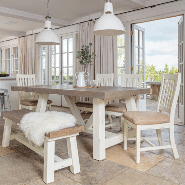 modern farmhouse dining table in front of open patio door with far left side of table extended. 4 x matching chairs on far side and bench in the foreground