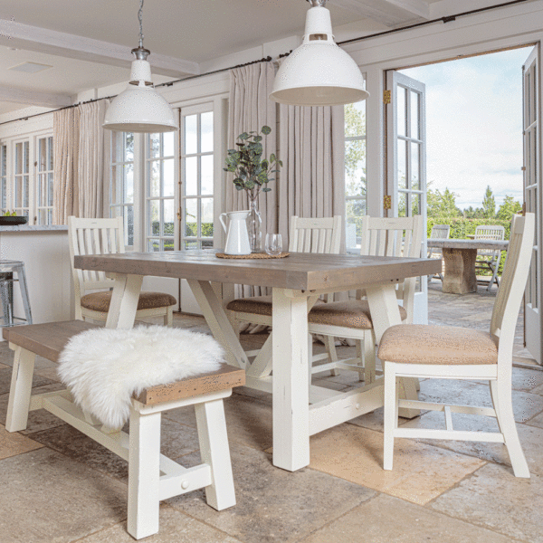 modern farmhouse extending dining table in front of open patio door with 4 x matching chairs on far side and bench in the foreground