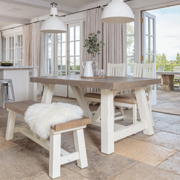 modern farmhouse extending dining table in front of open patio door with 2x matching chairs on far side and bench in the foreground
