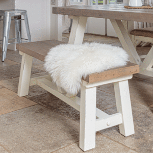 small modern farmhouse bench with white fleece draped over seat
