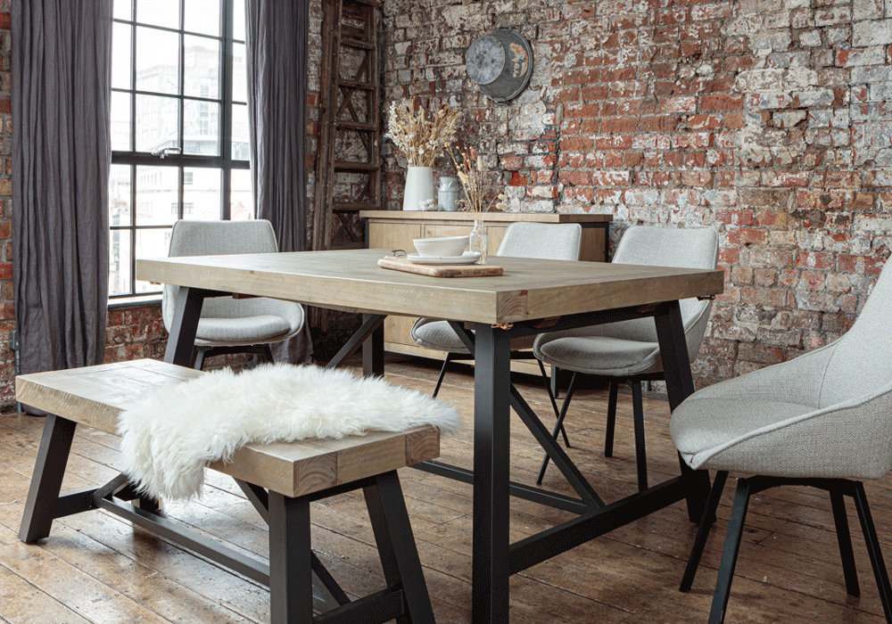 Urban dining table set with dining bench and fabric chairs placed in a room with industrial style decor