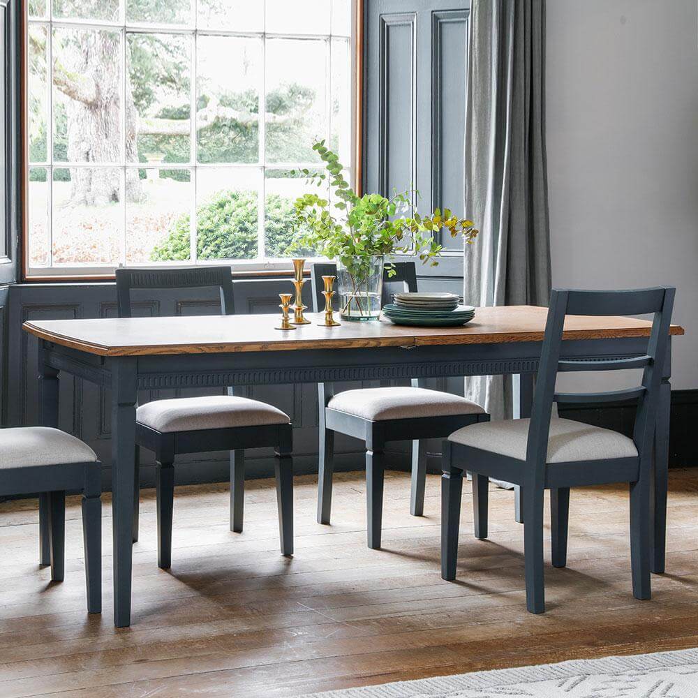 The Atlantic Extending Dining Table Set in Blue Grey placed in front of a large window
