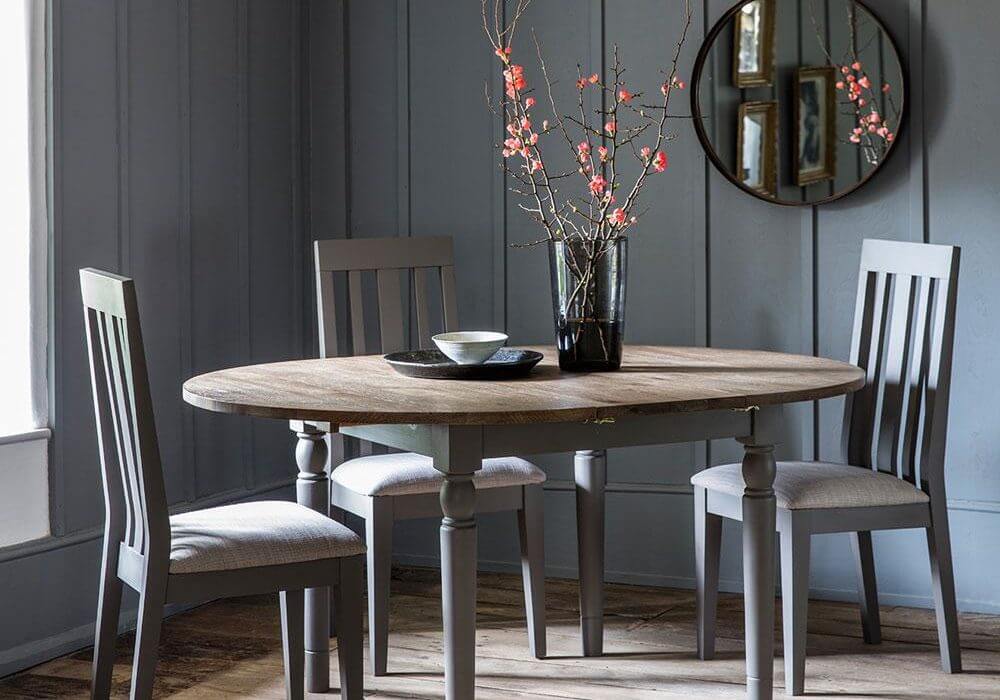 The Rural Round Extending Oak Dining Table Set In Slate Grey (1.2m) with flowers