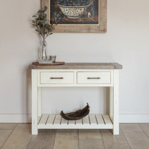 modern farmhouse console table with vase and candle on top surface- pictured under painting of fruit bowl on wall
