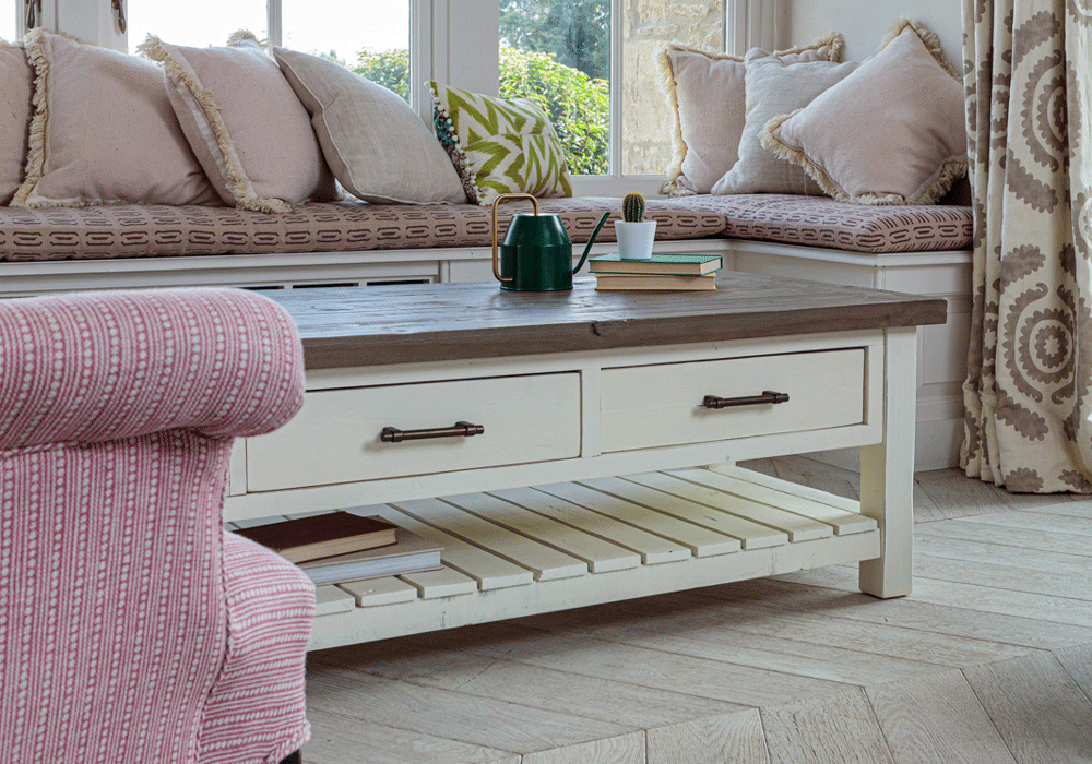 modern farmhouse rustic coffee table with drawers in front of window seat with pink armchair in foreground