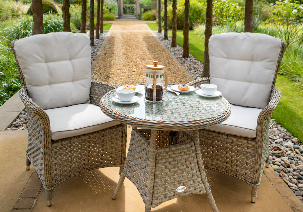 Hartman Heritage Beech Glass Bistro Set at the end of garden path with tea set on table top and greenhouse in background
