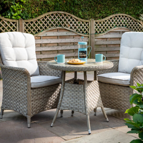 Two_chairs_in_garden_setting_with_white_cushions_and_table