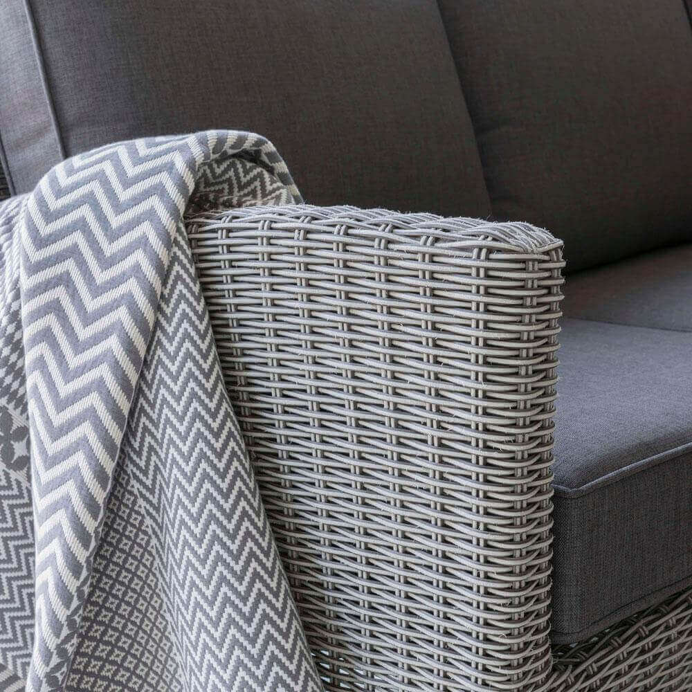 close up of rattan weave sofa from Kettler Palma corner set with throw placed on top