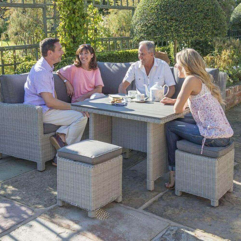 Kettler Palma mini corner set placed on a patio with people sat around the table enjoying tea