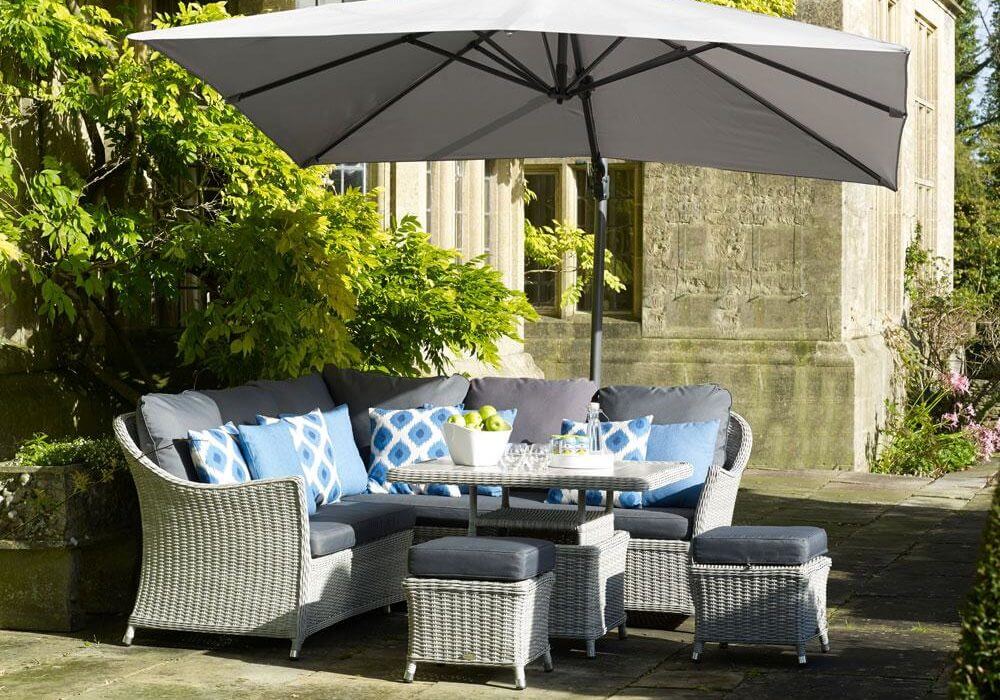 garden dining table set with parasol placed on an outdoor patio in the shade