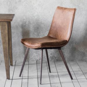 leather montana chair in brown placed on a grey floor