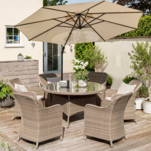 2021 Kettler Charlbury 6 Seat Garden Dining Set With Round Table In a garden under a tilted parasol