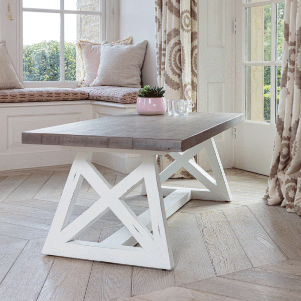white and grey coffee table full image angled on a wooden floor next to big window and patio door