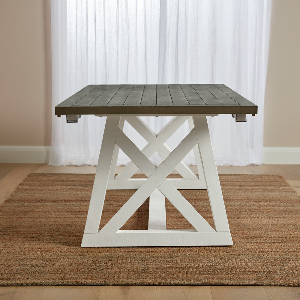 side angle of white and grey extendable dining table showing cross base and grey table top
