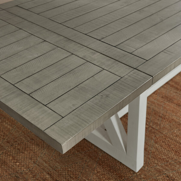 angled shot showing a grey tabletop of a white and grey extendable dining table with extension leaf fully inserted