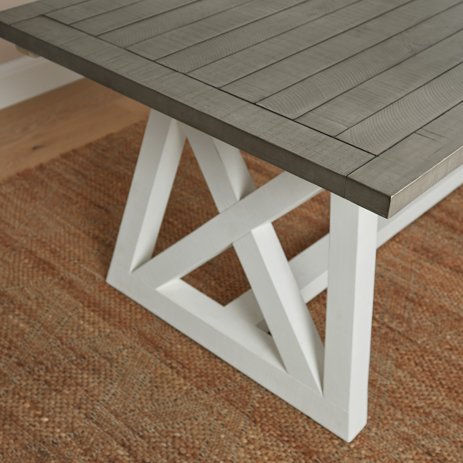 angled shot of grey tabletop of a white and grey extendable dining table