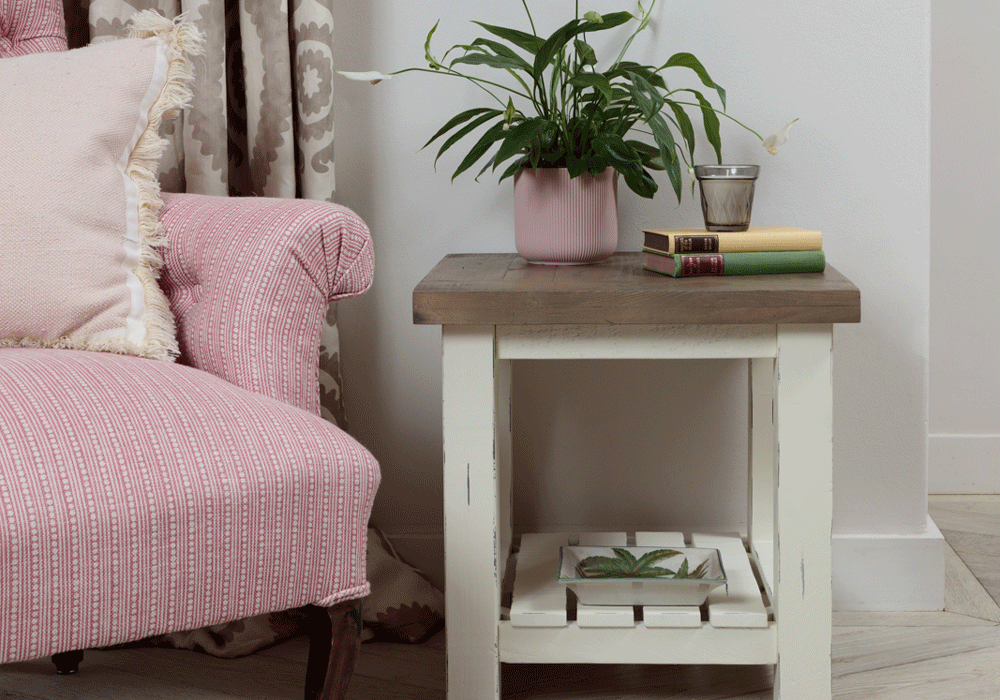 modern farmhouse side table with objects on top next to pink armchair