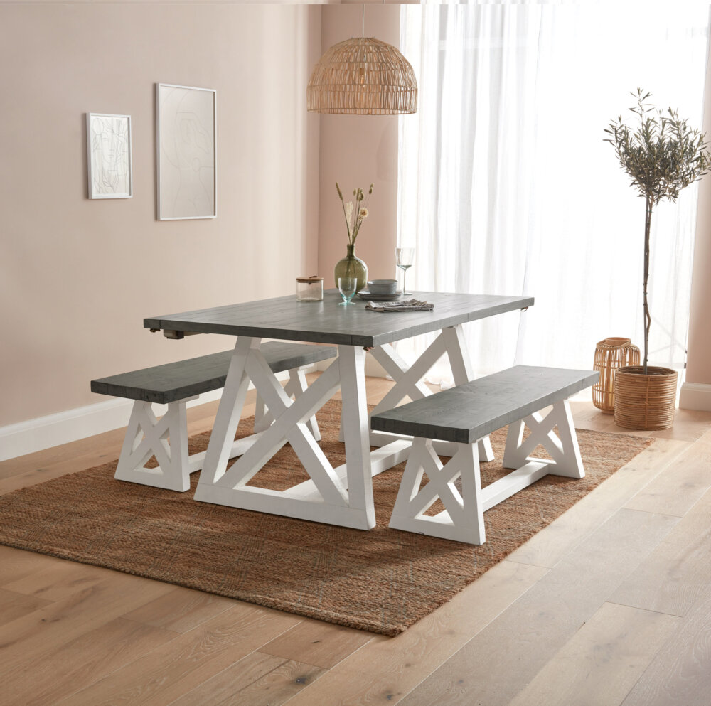 wood dining table with white base and grey tablet tops with two matching benches in dusky lit room