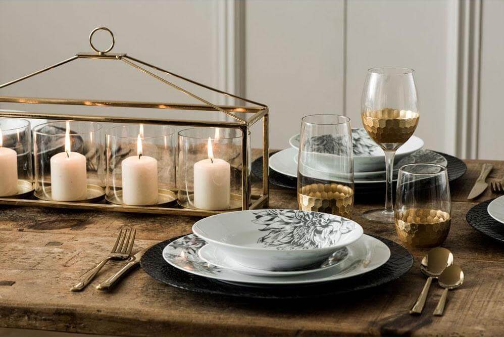 dinner table set with candles and gold glassware