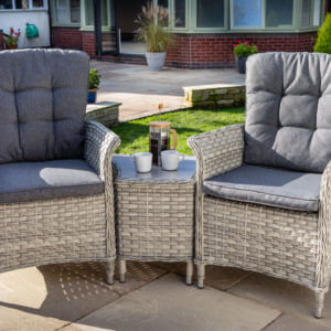 zoomed in Bramblecrest Monterey garden sofa set in a walled garden next to house