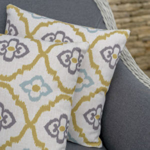 Close up of Bramblecrest Moroccan citrus square scatter cushion on outdoor chair