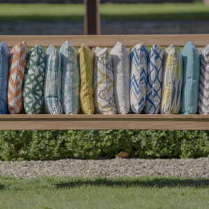 Close up of variety of bramblecrest square scatter cushions on outdoor bench
