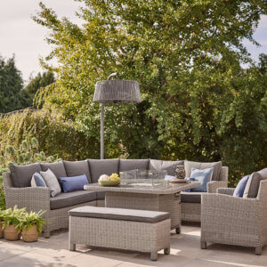 The Kettler Palma Grande with Firepit Table, Chair And Bench Amongst Foliage