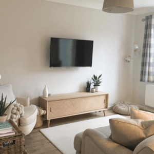 Pale living room interior with flat screen TV on wall
