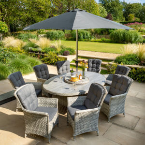 2021 Hartman Heritage 8 Seat Elliptical Dining Set with Lazy Susan and 3 Metre Parasol On A Patio Next to a lawn