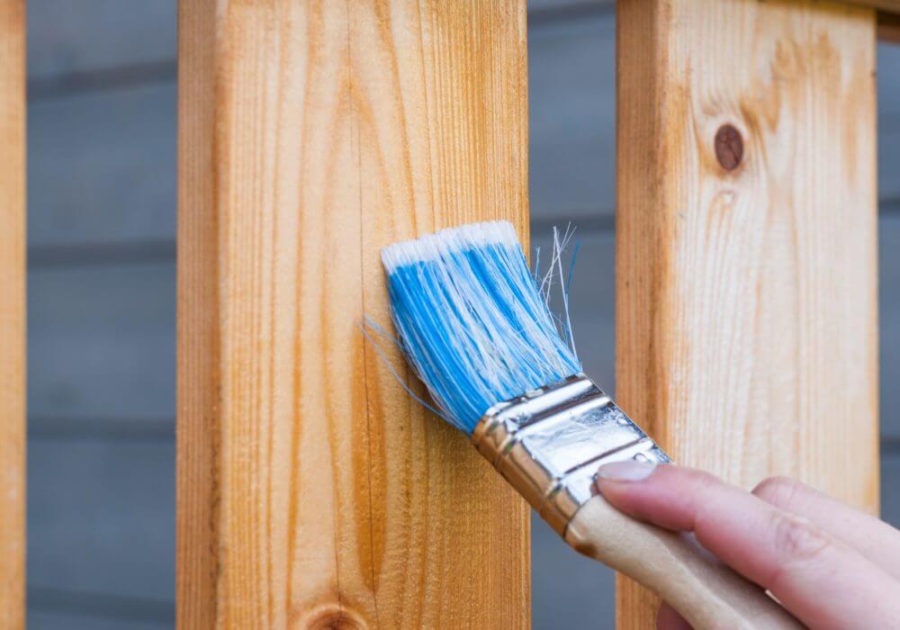 close up of blue brush painting wooden slat