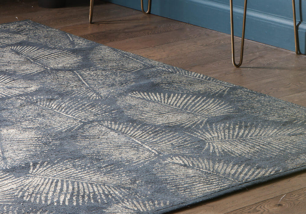 Lyme Coast Rug Charcoal Gold- indoors next to gold table legs