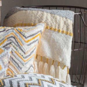 Tassel textured Throw Ochre/Grey against wire basket with same colour cushion