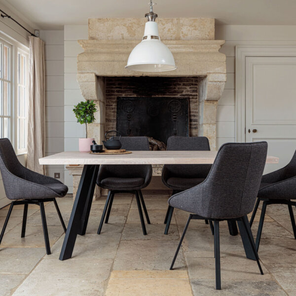 Valencia Light Oak Dining Set With 5 X Gaudi Dark Grey Dining Chairs in front of large stone fireplace