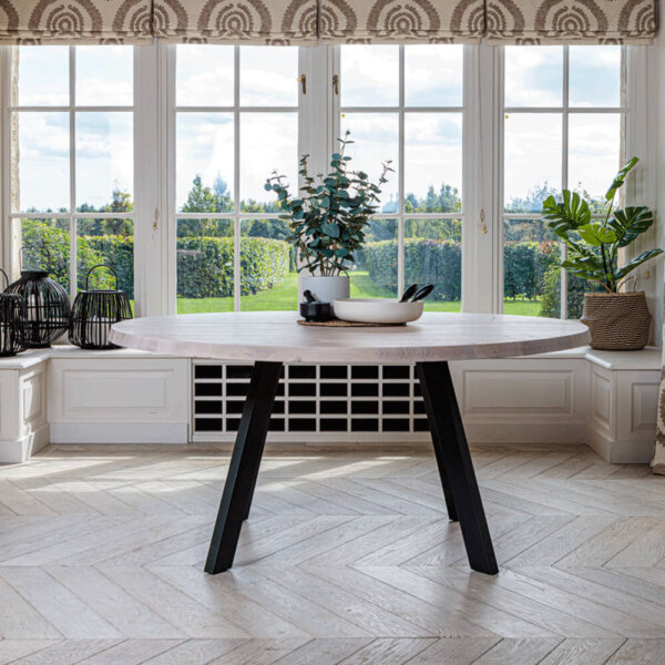 Valencia Natural Oak 1.6m Round Table in front of garden view bay window