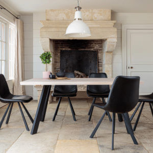 Valencia Light Oak Dining Set With 5 X Dali Black Leather Chairs in front of large stone fire place
