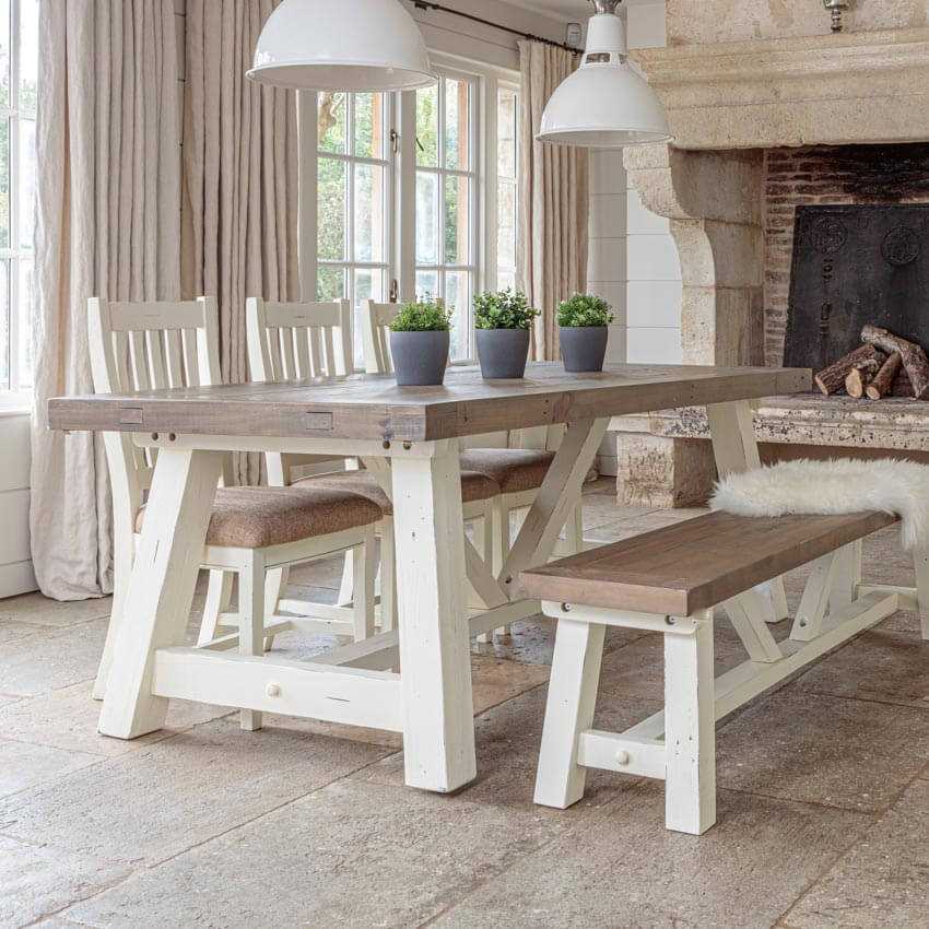 white and grey modern farmhouse extendable dining table set with matching bench and 3 chairs in front of window and stone fireplace