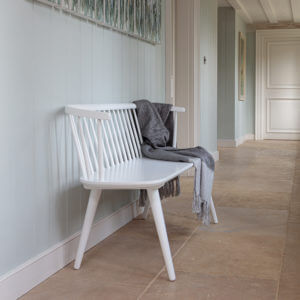 Brunswick dining bench in true white in stone floored corridor