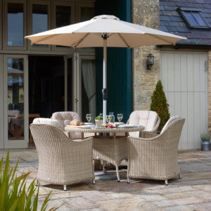 Garden_Furniture_With_Parasol_In_front_Of_Country_House_Plant_In_foreground