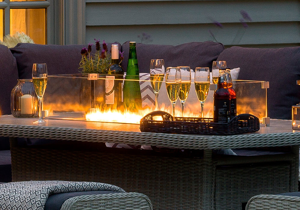 Smoldering_Fire_Pit_Integrated_Into_Dingin_table_With_Items_On_table_At_Dusk