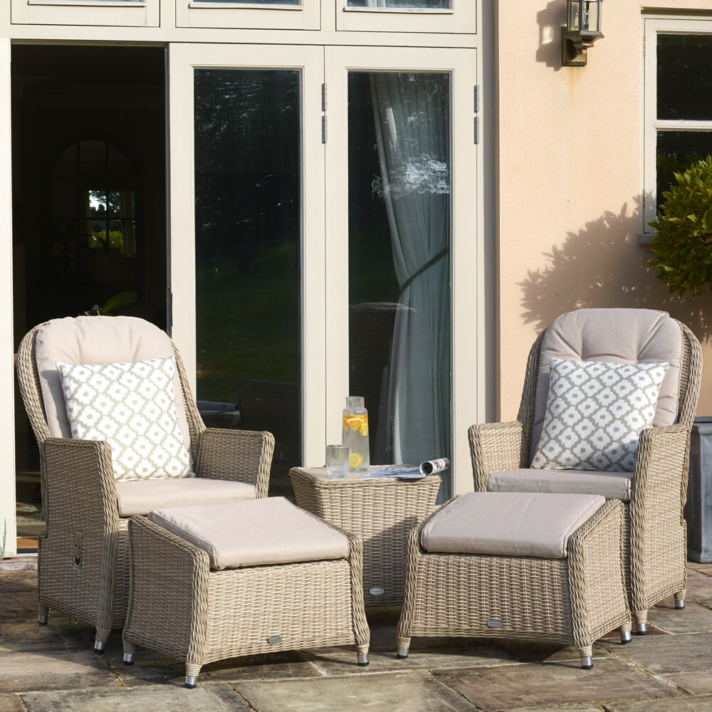 Bramblecrest Monterey Reclining Garden Chairs In Front Of House With Patio Doors with a small rattan table between them