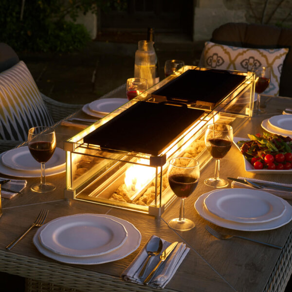 Griddles_On_Fire_Pit_On_Dining_Table_at_Dusk_With_Corckery