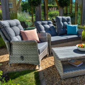 reclining_armchair_amongst_other_furniture_in_sunny_flower_garden