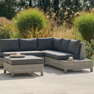garden_furniture_with_grey_cushions_on_paving_against_bushes