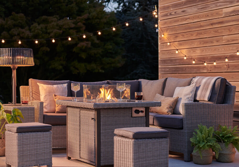 Kettler Palma Mini Firepit garden table set in an outdoor setting at dusk
