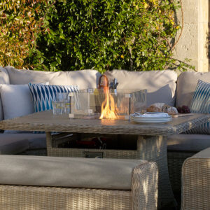 Bramblecrest Monterey Square Casual Firepit Dining Table Set in garden space with fire lit
