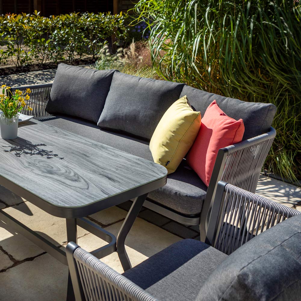 Hartman Dubai 3 seater garden sofa set placed on a patio next to greenery and foliage